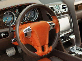 Modern luxury car Interior. orange leather steering wheel, shift lever and dashboard. Car interior luxury inside