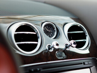 The grille of the air deflector with clock of a modern luxury car close up