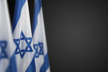 Israel flags with a star of David over dark gray background. Banner with place for text.