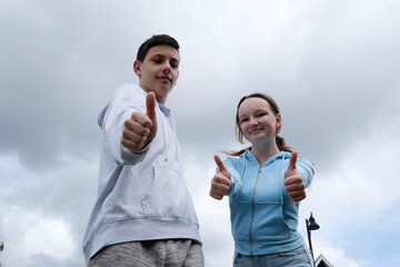 teenagers on the background of the sky Happy man and woman with dirndl hold thumbs up.Isolated on...