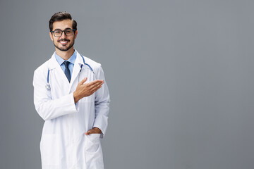 Male smile doctor in a white coat and glasses for vision and a stethoscope looks at the camera with...
