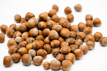 Pile of hazelnuts in a shell on white background