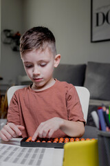 Little boy Counting with help an abacus. Mental arithmetic, brain development