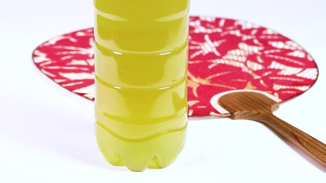 ペットボトルに入った緑茶と団扇　回転