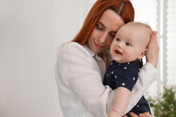 Mother with her cute baby at home, space for text
