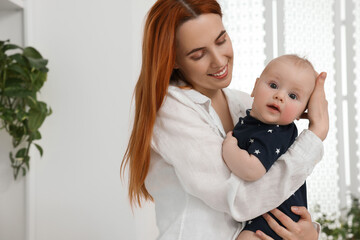 Mother with her cute baby at home, space for text