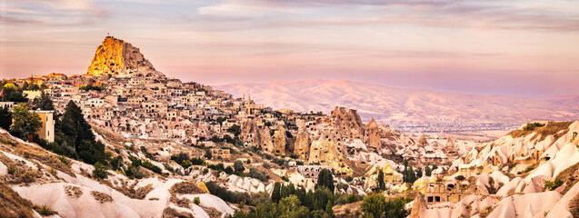 Uchisar Castle panorama as viewed from Pigeon Valley at sunset. Situated on the edge of Goreme National Park, Uchisar consists of an old village huddled around the base of a huge rock cone