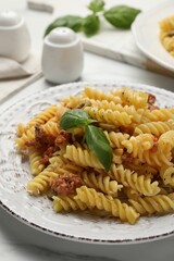 Delicious pasta with minced meat and basil served on white table, closeup