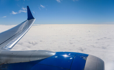 aerial view from a window seat captures the majestic airplane wing soaring through the clouds, symbolizing freedom, adventure, and travel. The view offers a sense of perspective