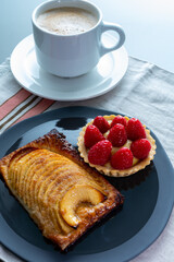 Breakfast with cup of black coffe and sweet baked tart with  ripe red raspberry and apple cake with cinnamon