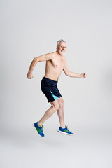 Portrait of senior smiling man doing exercises, isolated on white background. Gray haired male