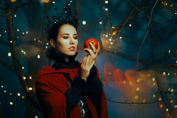 Evil Queen Holding a Red Poisonous Apple as Bait. Fantasy fairy tale villain planning a witchcraft...