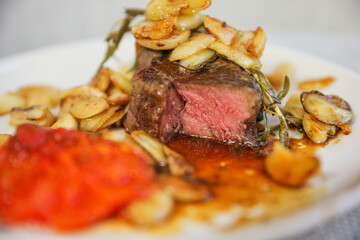 A mouth-watering steak dinner with tomato and garlic represents a balance of indulgence and healthy nourishment. Symbolizing strength, vitality, and a celebration of life