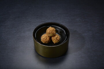 mini bake luxury tart in Japanese hojicha crisp with cranberry pineapple jam paste inside with clove stick and black plate gold fork knife on dark background pastry dessert halal party food menu