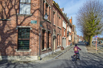 Fototapeta na wymiar brick buildings on corner in Bruges Belgium with generic biker