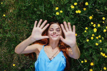 Woman smile with teeth lies on the green grass with yellow flowers, happiness without allergies