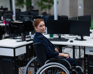 Caucasian woman in wheelchair at work desk.