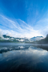 雲と霧に霞む早朝の上高地の大正池