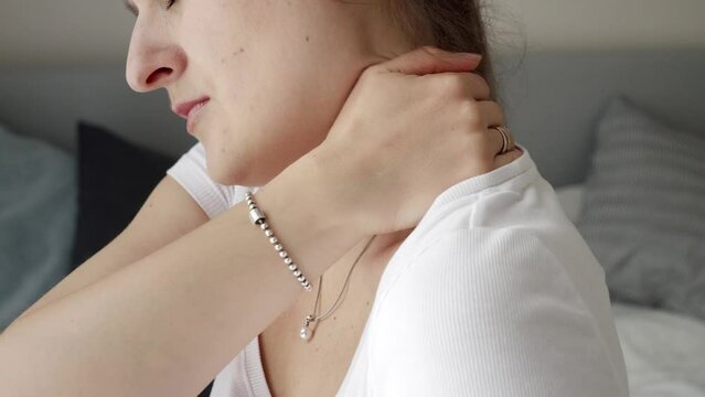 Closeup of young woman massaging her neck feeling pain. Concept of healthcare problems, pain relief and injuries