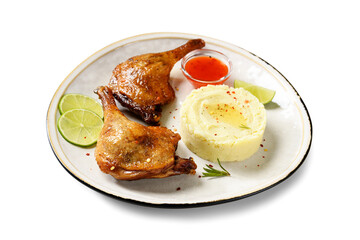 Freshly roasted duck legs confit served with potato puree and lime slices. isolated on white background