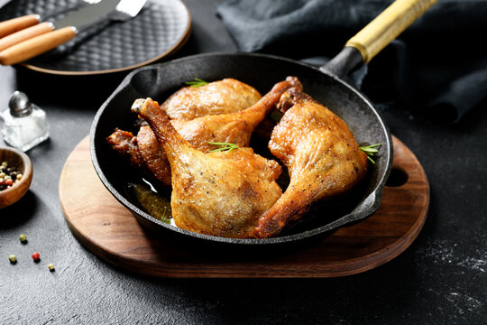 Freshly roasted duck legs confit in  pan,  black background