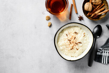 Fresh prepared rice pudding garnished with cinnamon flakes. Healthy breakfast for every day. Light gray background, top view