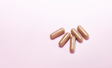 Closeup Few Beige Softgel Capsules OF Slippery Elm On Pink Background. Dietary Nutritional Supplement, Medication. Ulmus Fulva, Herbal Remedy Concept. Horizontal, Copy space For Text