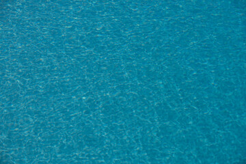 Ripped water in swimming pool. Surface of blue swimming pool, background of water.