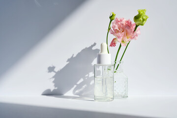 Serum with a dropper with spring flowers.
