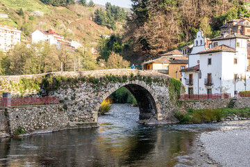 Fototapeta na wymiar bridge of Roman origin on the Narcea river as it passes through the center of the city of Cangas del Narcea in Asturias, Spain