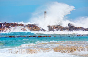 Fototapeta na wymiar Beautiful red and white lighthouse on the rocks with strong sea wave - Namibia, Africa