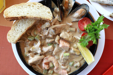 Seafood stewed in creamy sauce in frying pan