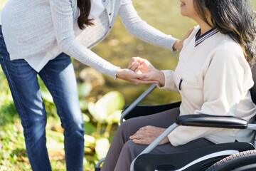 Fototapeta na wymiar Nursing home. Young caregiver helping senior woman in wheelchair.
