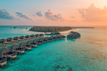 Sunset Maldives paradise island. Tropical aerial landscape, seascape water bungalows villas, amazing sea lagoon beach. Exotic tourism destination, summer vacation background. Beautiful aerial travel