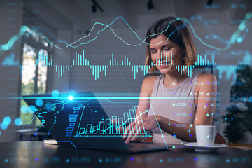 Thoughtful businesswoman in casual wear typing on laptop at office workplace with coffee cup. Concept distant work, business education, internet surfing, information technology. Forex chart and graph