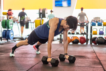 Fototapeta na wymiar Hard Training In The Gym. Woman At The Health Club