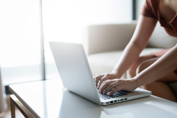 Close up Female typing on laptop keyboard working with digital data..