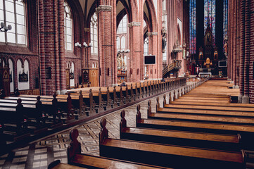 Fototapeta na wymiar Rows of church benches at the old european catholic church.