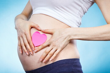 Woman in pregnant with pink heart on her belly. Expecting for newborn. Extending family