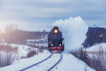 Retro steam train moves at winter morning time.