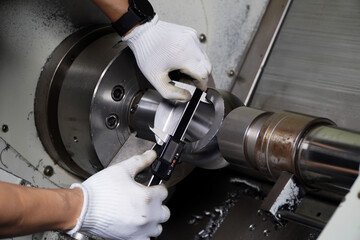 Metalworking industry.Hands of an engineer measures a metal part with a digital vernier caliper, CNC ,Machine Parts.