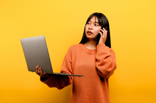 Online Communication Concept Asian Girl Use Laptop At Home Yellow Studio Photo She Is Happy To Spend Her Free Time Online While Chatting With Friends On Social Networks, Shopping Or Working Online.