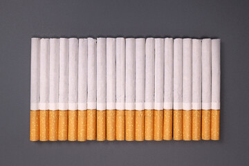 row of cigarettes on a gray background, the harm of smoking, nicotine addiction