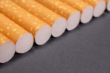 row of cigarettes on a gray background, the harm of smoking, nicotine addiction