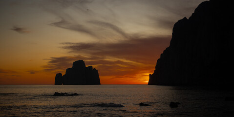 super sunset in the south of sardinia in front of the stack of sugar loaf, masua, iglesias
