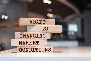 Wooden blocks with words 'Adapt to changing market conditions'.