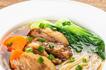 Spicy red soup beef noodle in a bowl on wooden table