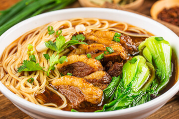 Spicy red soup beef noodle in a bowl on wooden table