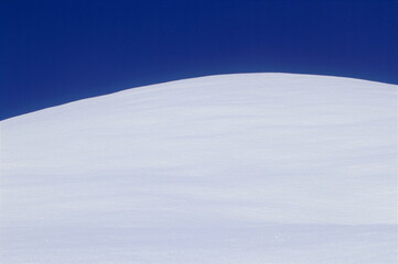 Fototapeta na wymiar 白い雪と青い空が描く美しいデザイン