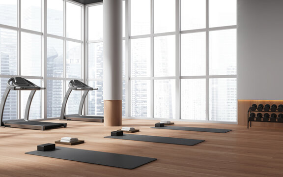 White gym corner with treadmills and yoga mats
